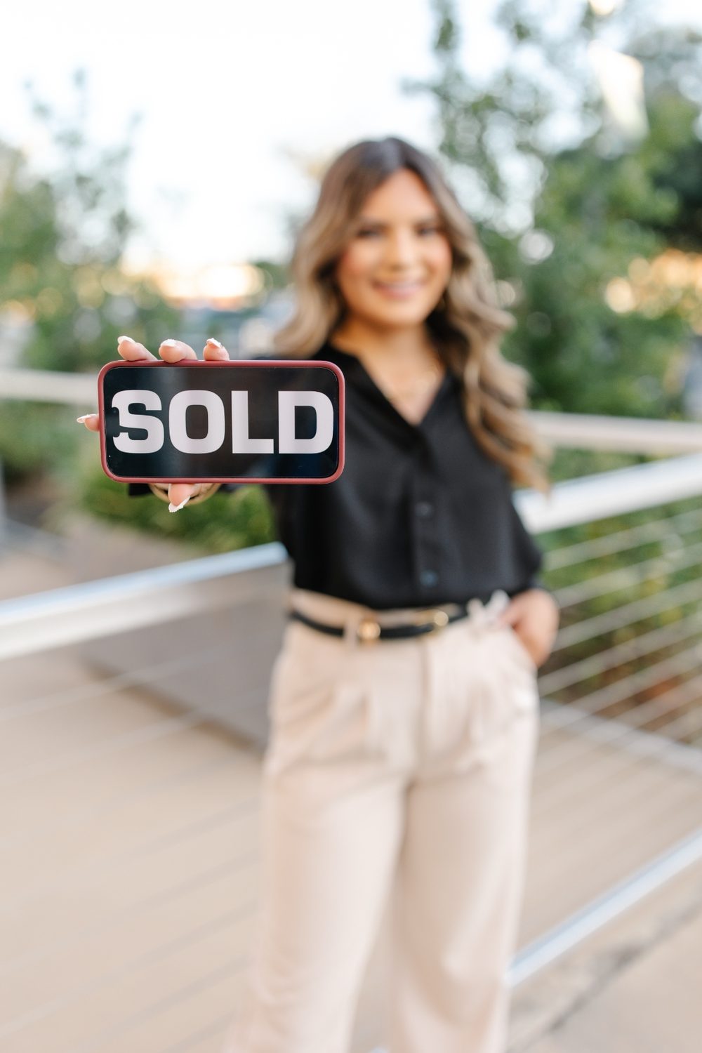 Danna Guille holding a SOLD sign